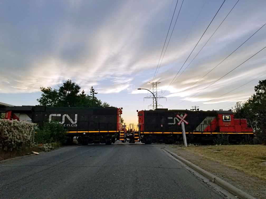 A CN Rail train crossing 34 Ave SE in Calgary. Although there's a level crossing there and a siding, it's not often that you see the train crossing the road. It's still best to assume it might be there though.